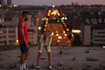 Fitness friends taking a break during night workout in the city