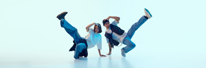 Expressive hip-hop dancers lifting legs in synchronized motion with serious facial focus. Concept...