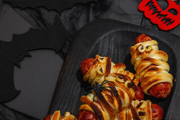 Spooky sausage mummies for Halloween party. Funny seasonal food, homemade baking, traditional decor
