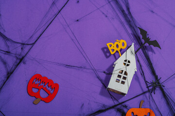 Funny Halloween background. Scary spider web, traditional fall pumpkins, house, bats and spiders