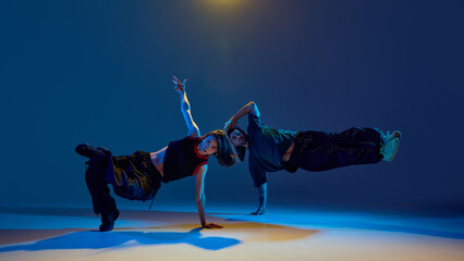 Breakdancers holding plank-like freeze with serious gaze and synchronized shape. Concept of street...