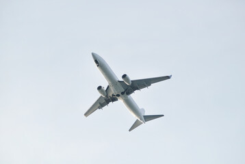 An airplane seen from below against a cloudless sky