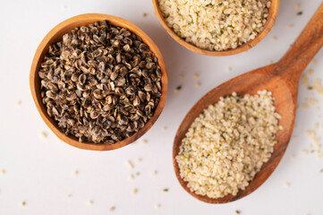 Hemp seeds in wooden spoon and bowls on light background. Superfood, healthy tasty organic hemp...
