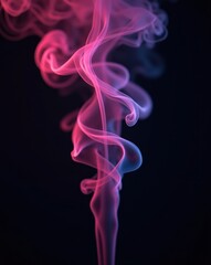 Obraz premium Ethereal plume of pink and blue colored smoke swirling gracefully in an abstract pattern against a dark background.