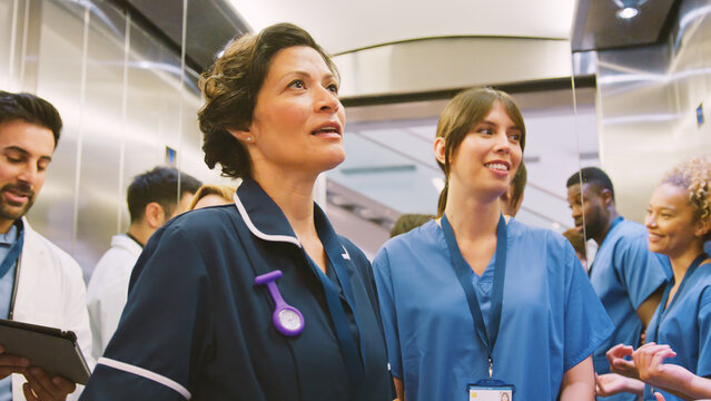Medical Team Standing In Lift Inside Modern Hospital Building - Powered by Adobe