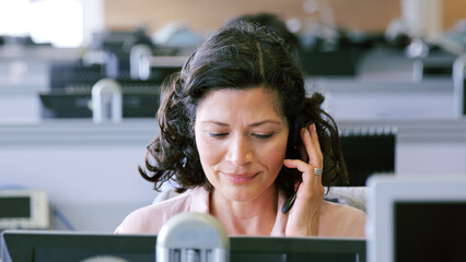 Mature Businesswoman Wearing Telephone Headset Working In Customer Services Department