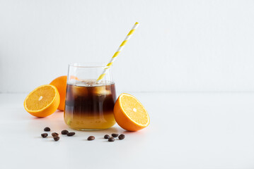 Layered Bumble Coffee with orange and espresso, served in a glass on white table