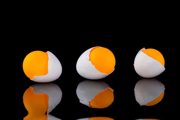 Egg shell with orange ball on a black background