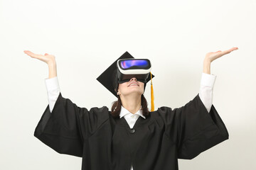 Graduated woman in black robe using VR headset for virtual learning and online education concept