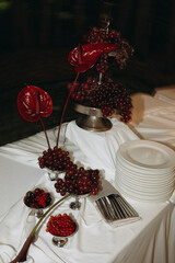 An Elegant Table Setting with Beautiful Red Accents and Fresh Grapes for Any Occasion
