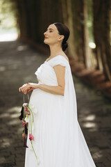 An Elegant Bride Poised Gracefully in a Serene Outdoor Setting Captured Beautifully