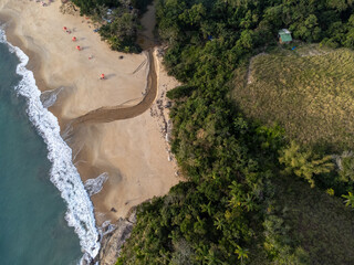 Top view of a beautiful beach with blue waters and a small river flowing into it