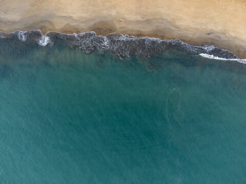 Wonderful tropical beach with blue water and orange sand forming small waves seen from above - Powered by Adobe