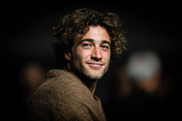 Obraz premium Captivating portrait of a smiling young man urban setting photography intimate atmosphere close-up authentic expression