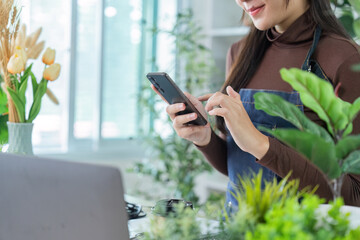 Digital Engagement. Woman using smartphone in plant shop, enhancing customer interaction.