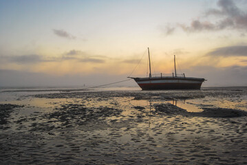 A photograph of a loan sailing dhow beached at a small secluded bay in Vilanculos Mozambique.