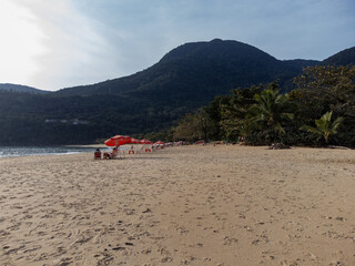 Fototapeta premium Late afternoon on a beautiful beach with a red umbrella