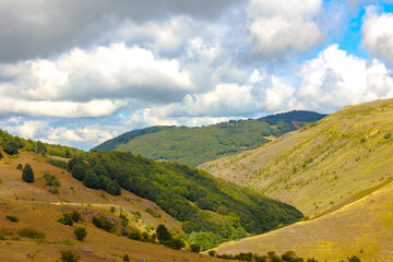 Mountain range with cloudy sky at daytime.