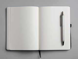 Open notebook with blank pages and a pen on gray background