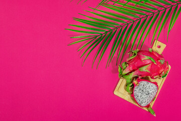 Fresh pitahaya on bright pink background. Dragon fruit harvest, tropical product