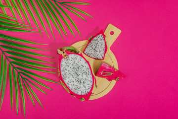 Fresh pitahaya on bright pink background. Dragon fruit harvest, tropical product
