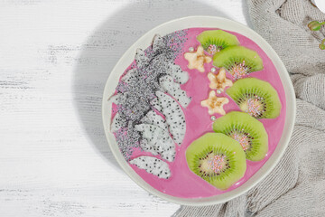 Pitaya smoothie bowl with fruit, kiwi, banana, and poppy seeds. Trendy food, healthy breakfast idea