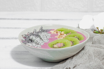 Pitaya smoothie bowl with fruit, kiwi, banana, and poppy seeds. Trendy food, healthy breakfast idea