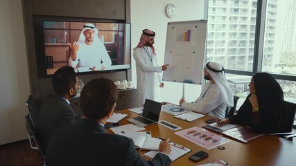 Western and emirati businesspeople in traditional arab attire participating in a conference with ceo, collaborating and taking notes in modern office environment - Powered by Adobe