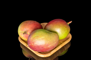 Ripe juicy mangoes on a black background, close-up.
