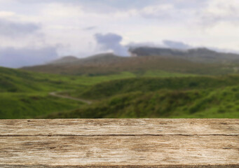 Wooden table top on blur mountain and grass field.Fresh and Relax concept.For montage product display or design key visual layout.View of copy space.