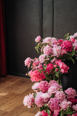 Bouquets of beautiful peonies in vases in a dark room