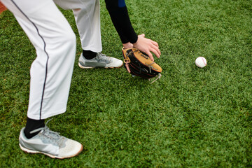 Sportsman eagerly fields baseball on a bright green sports field