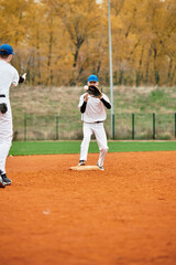 Obraz premium Two teenage boys enjoy a friendly baseball match on a vibrant autumn day