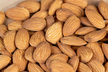 a lot of almonds on the table, ready-to-eat almond nuts on a wooden table, close up
