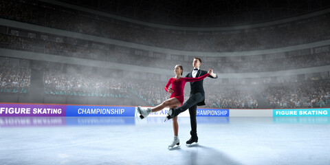 Figure skating couple skating on ice stadium.