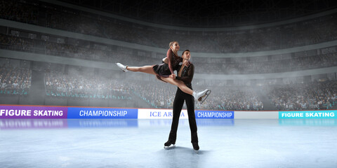 Figure skating couple skating on ice stadium.