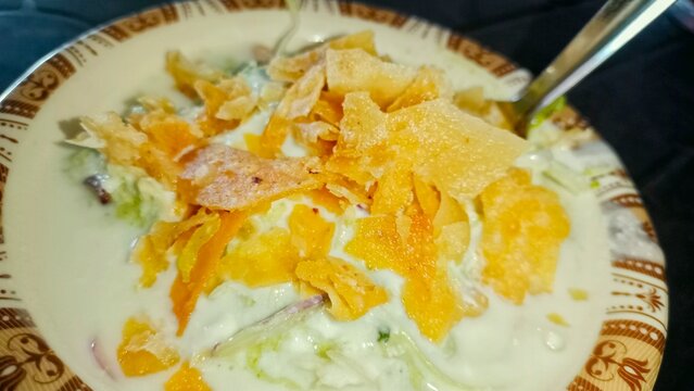 World food day,A delicious plate of savory chaat,featuring a mix of crispy fried dough pieces topped with a creamy yogurt sauce, garnished with chickpeas,