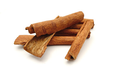 cinnamon sticks stacked on white background.
