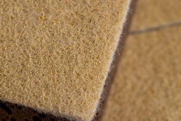 glued and tightly intertwined synthetic sand-colored threads on a sponge that is used for cleaning...