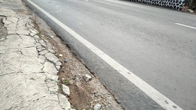 asphalt road in the morning. pedestrian crossing on the street. stone wall texture. walking on the street. pedestrian crossing the road. asphalt road with a crack. asphalt road texture. asphalt road