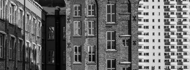 Intricate Contrast of Historic Brick Architecture and Modern Geometric High Rise Facade in Black...