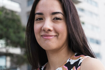 Young latin woman smiling in an urban setting