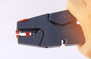 Hand holding electrical tools to assemble the electrical control panel. 