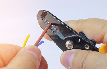 Hand holding electrical tools to assemble the electrical control panel. 