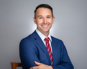 Portrait of white male professional in a blue suit and red tie. 