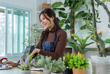 Sustainable Gardening. Smiling woman in apron engaging with customers in a plant shop.