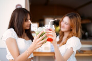 Friends enjoying refreshing drinks at a summer cafe during sunny afternoon in vibrant atmosphere