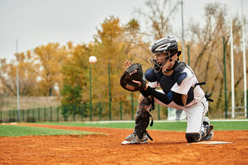 Young athlete showcases skill catching a pitch on a vibrant baseball field during autumn