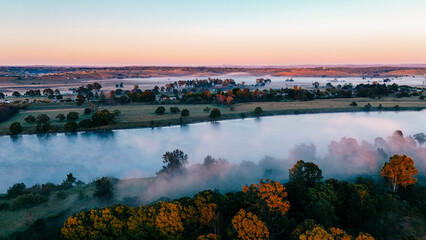 The mist rises slowly from the river and nearby land as a new day begins.