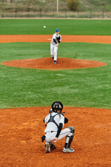 Two teenage boys in a competitive baseball match on a sunny field
